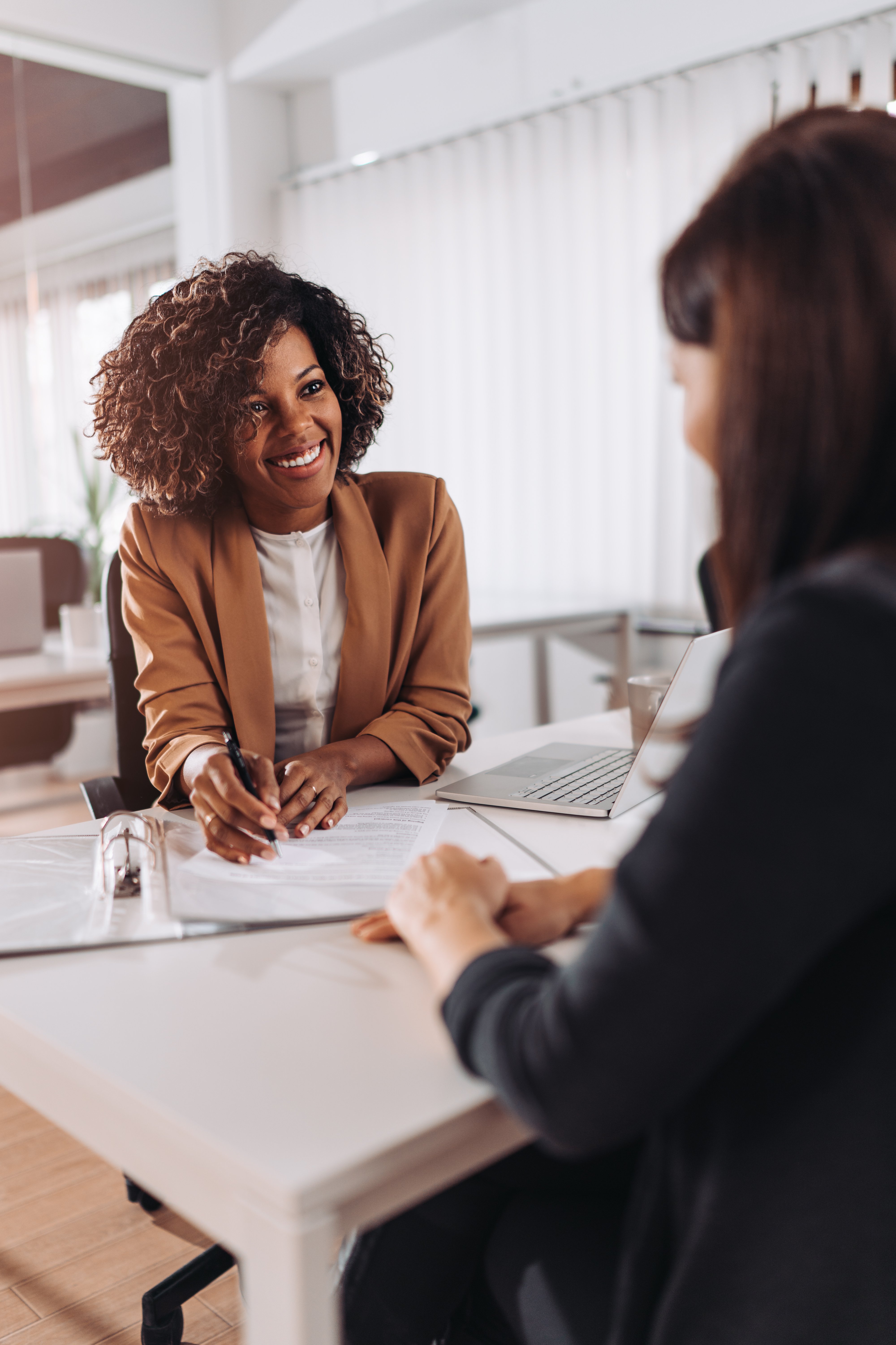 Woman smiling at desk over papers